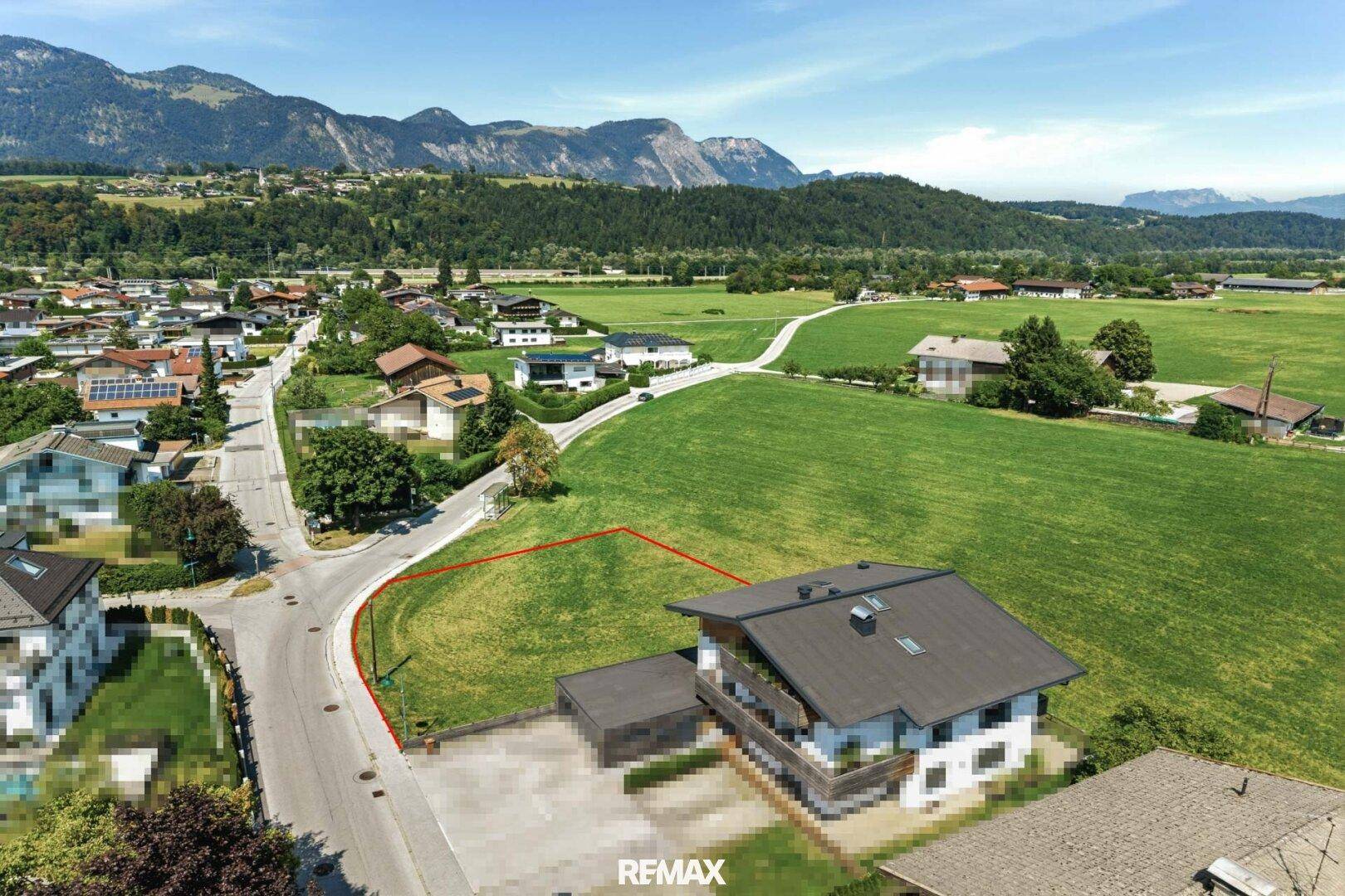 Luftbild eines Baugrundstücks am Rande einer Siedlung mit weitem Blick ins Grüne.