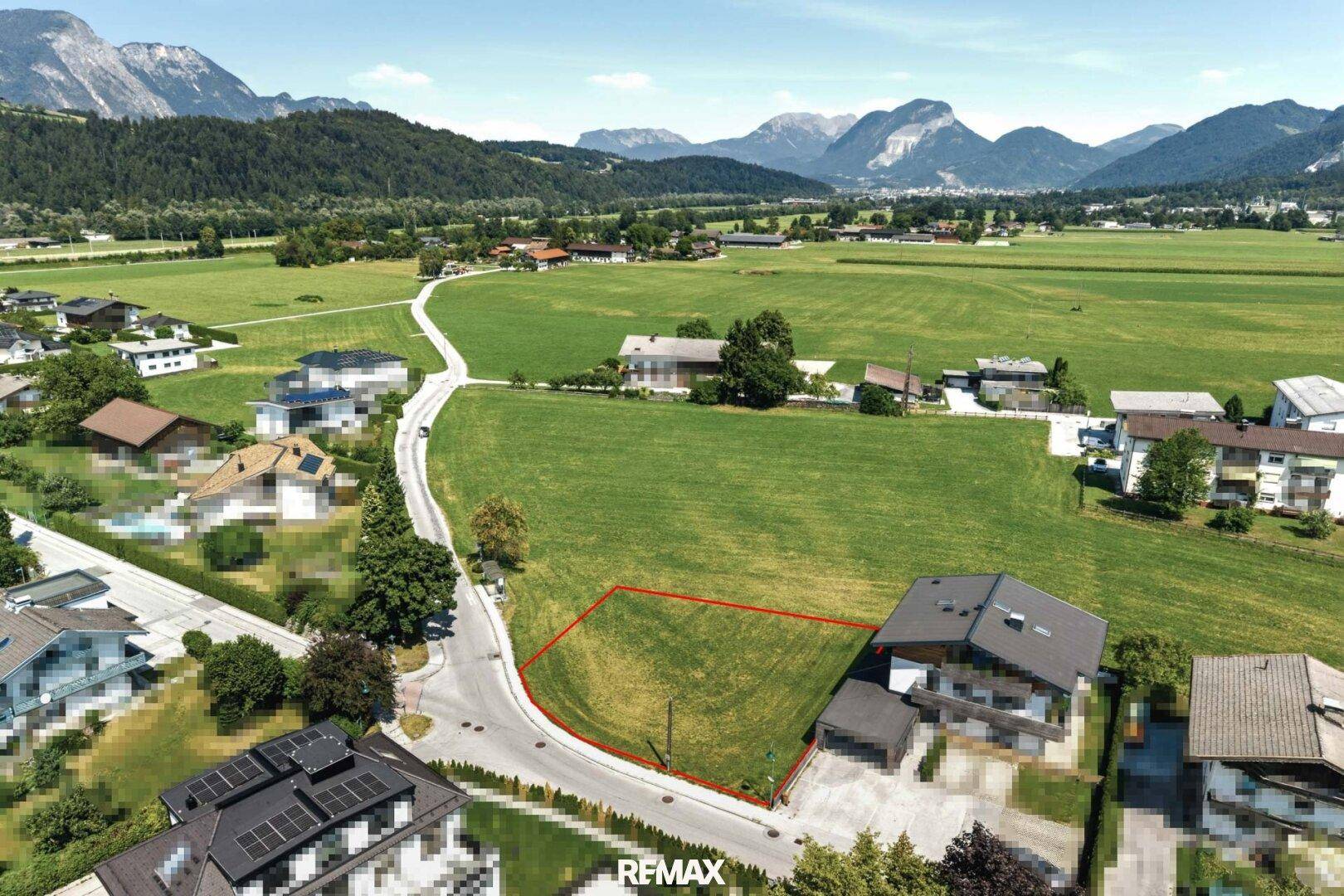 Panoramablick auf ein sonniges Baugrundstück in einer idyllischen Berglandschaft.