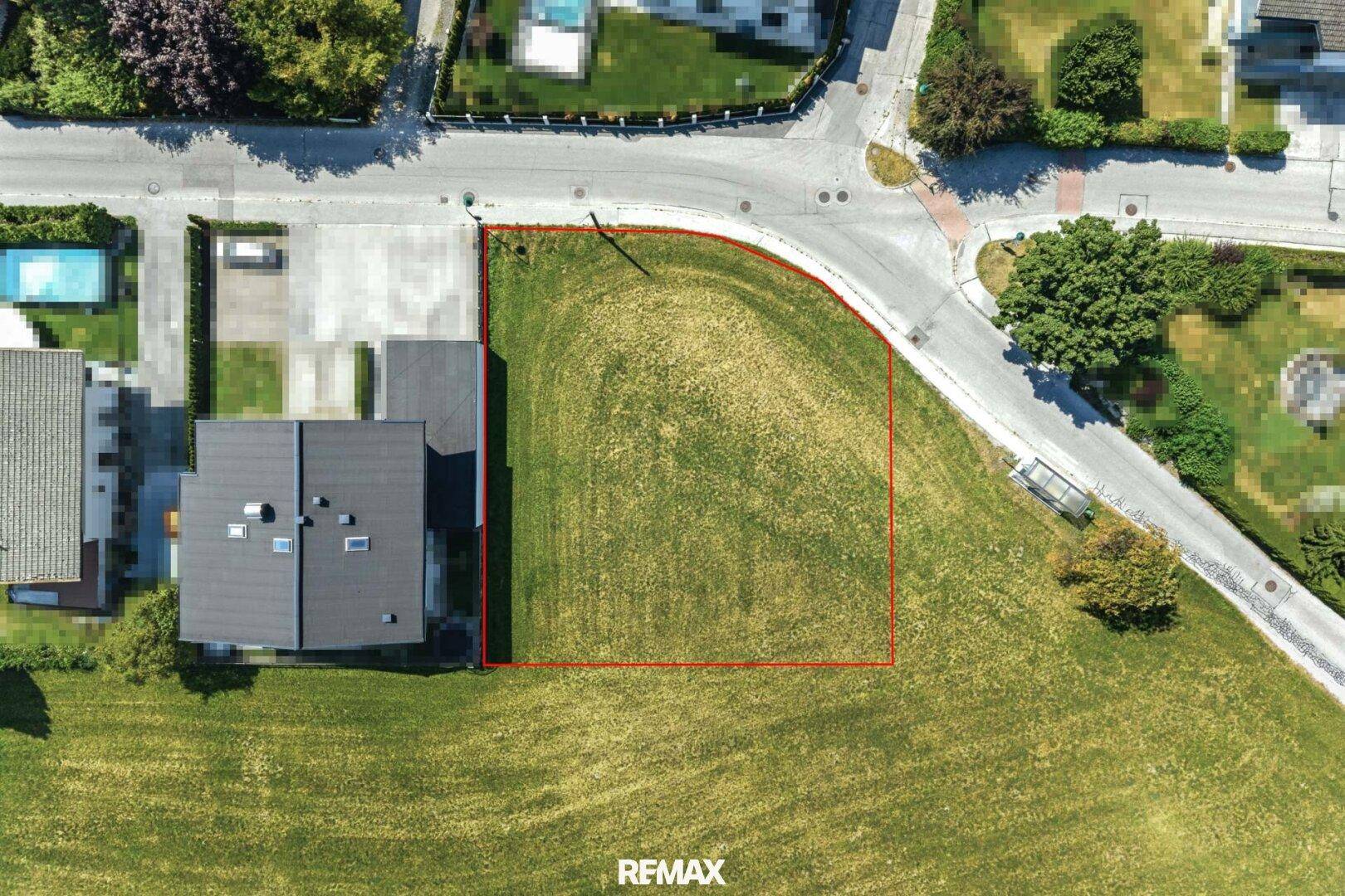 Detaillierte Draufsicht auf ein Baugrundstück an einer Straßenecke in grüner Umgebung.