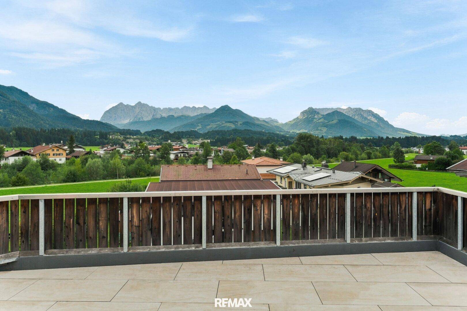 Geräumige Terrasse mit Fliesenboden und weitem Blick auf die umliegende Berglandschaft.