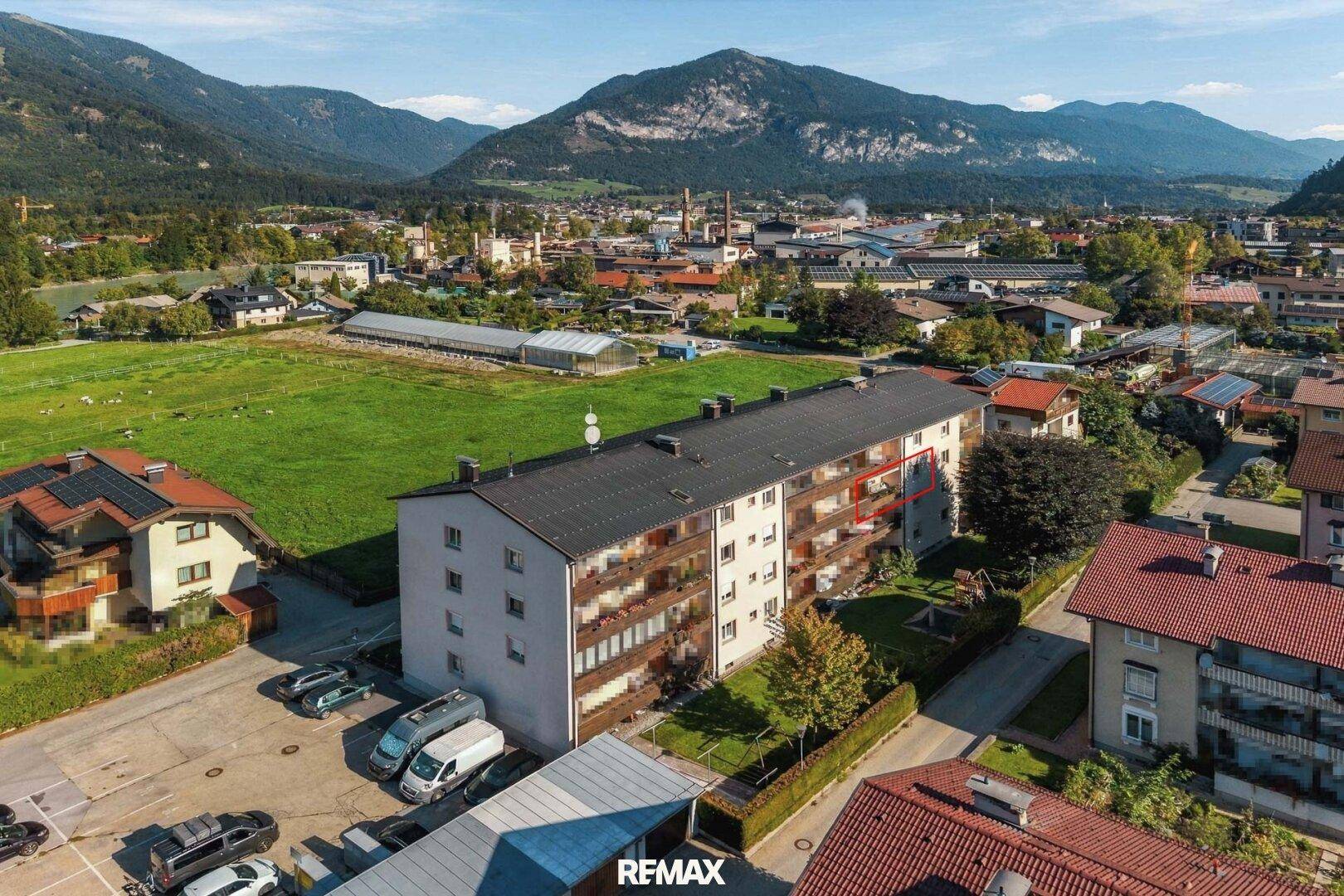 Luftaufnahme des Wohngebäudes in einer grünen Umgebung mit Bergblick.