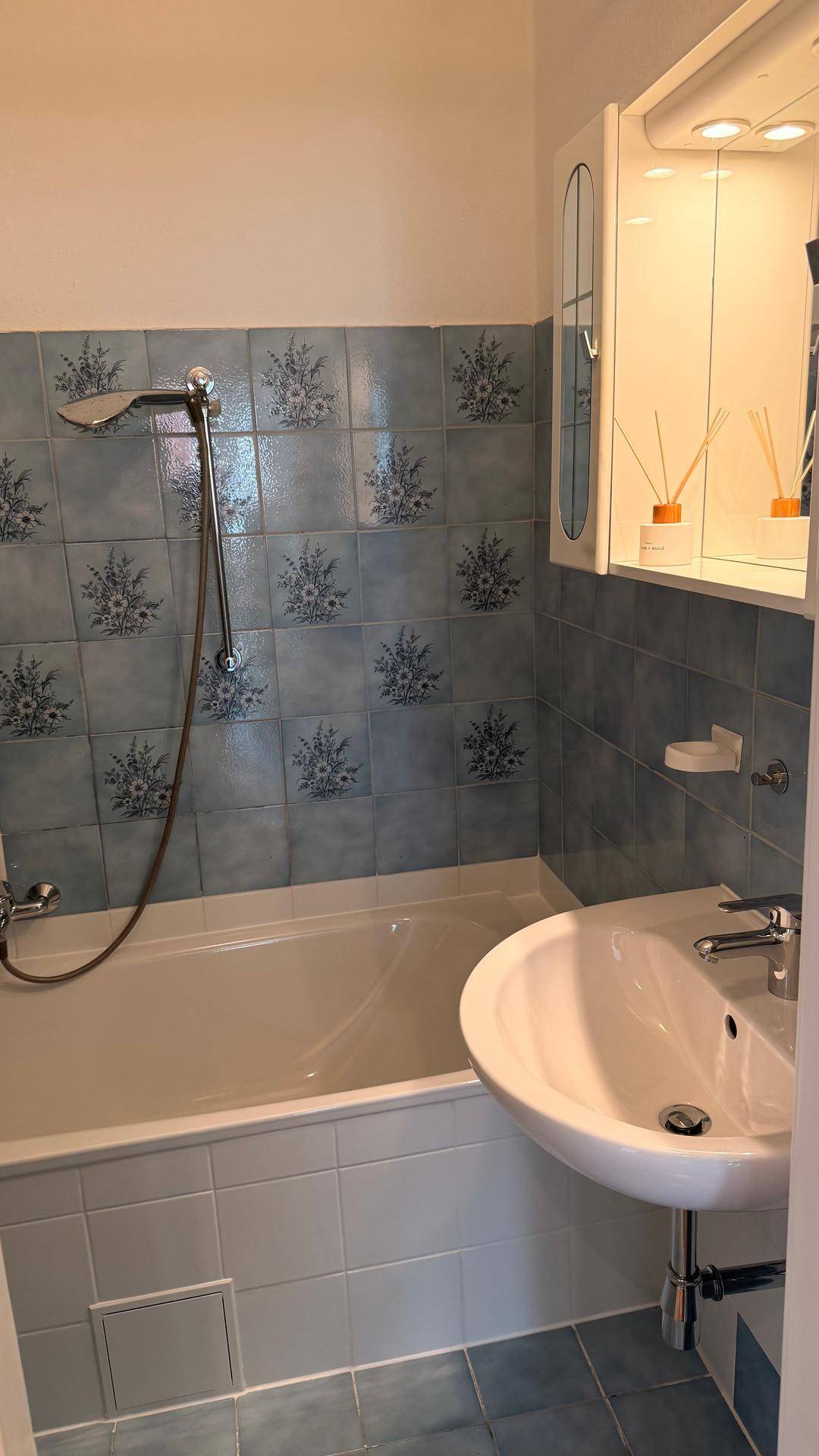 Badezimmer mit Badewanne, Waschbecken und blauen Fliesen im traditionellen Stil.