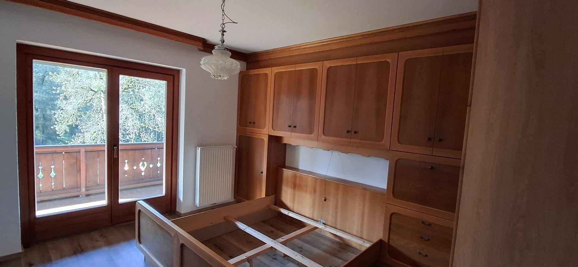 Schlafzimmer mit Holzbettrahmen und Einbauschränken, die viel Stauraum bieten.