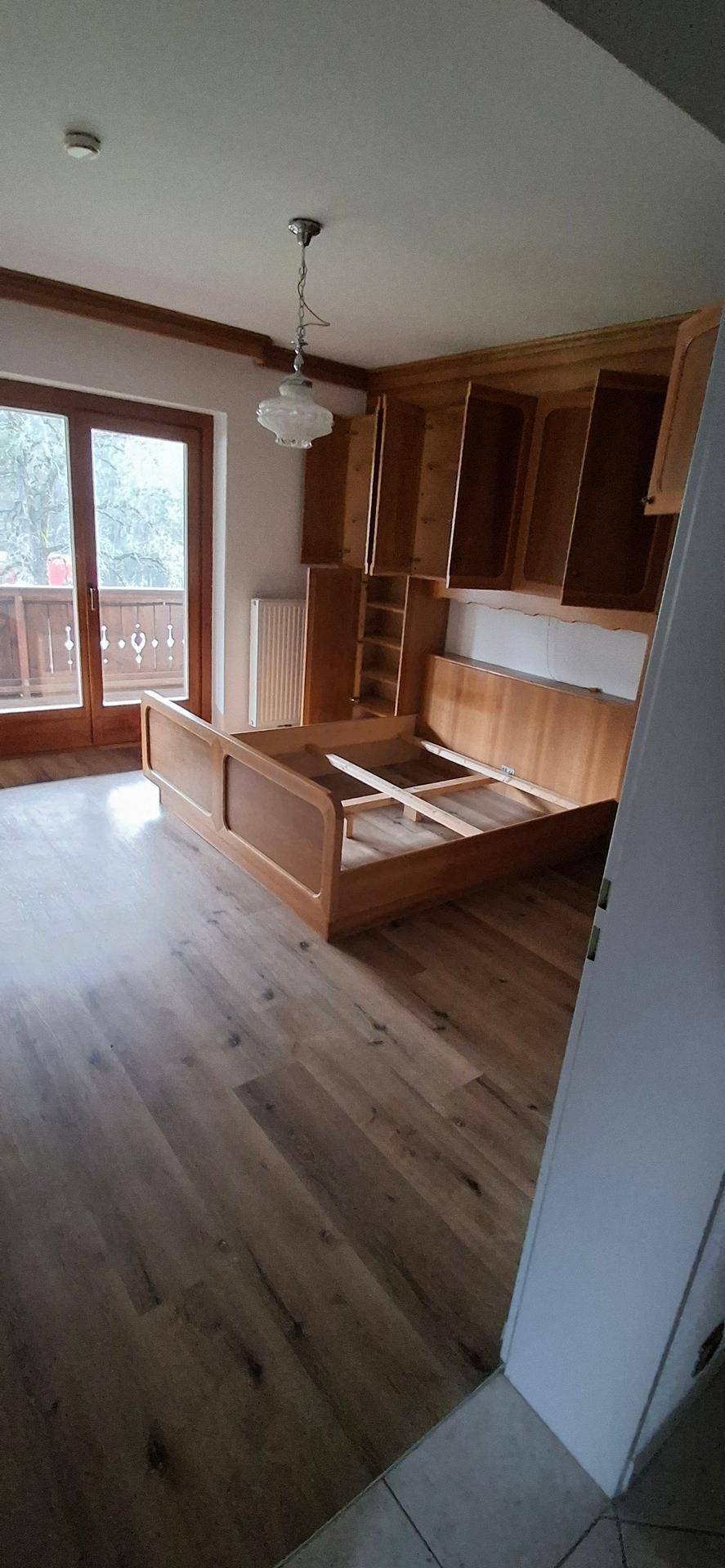 Helles Schlafzimmer mit Balkonzugang und Einbauschränken, die eine funktionale Einrichtung bieten.