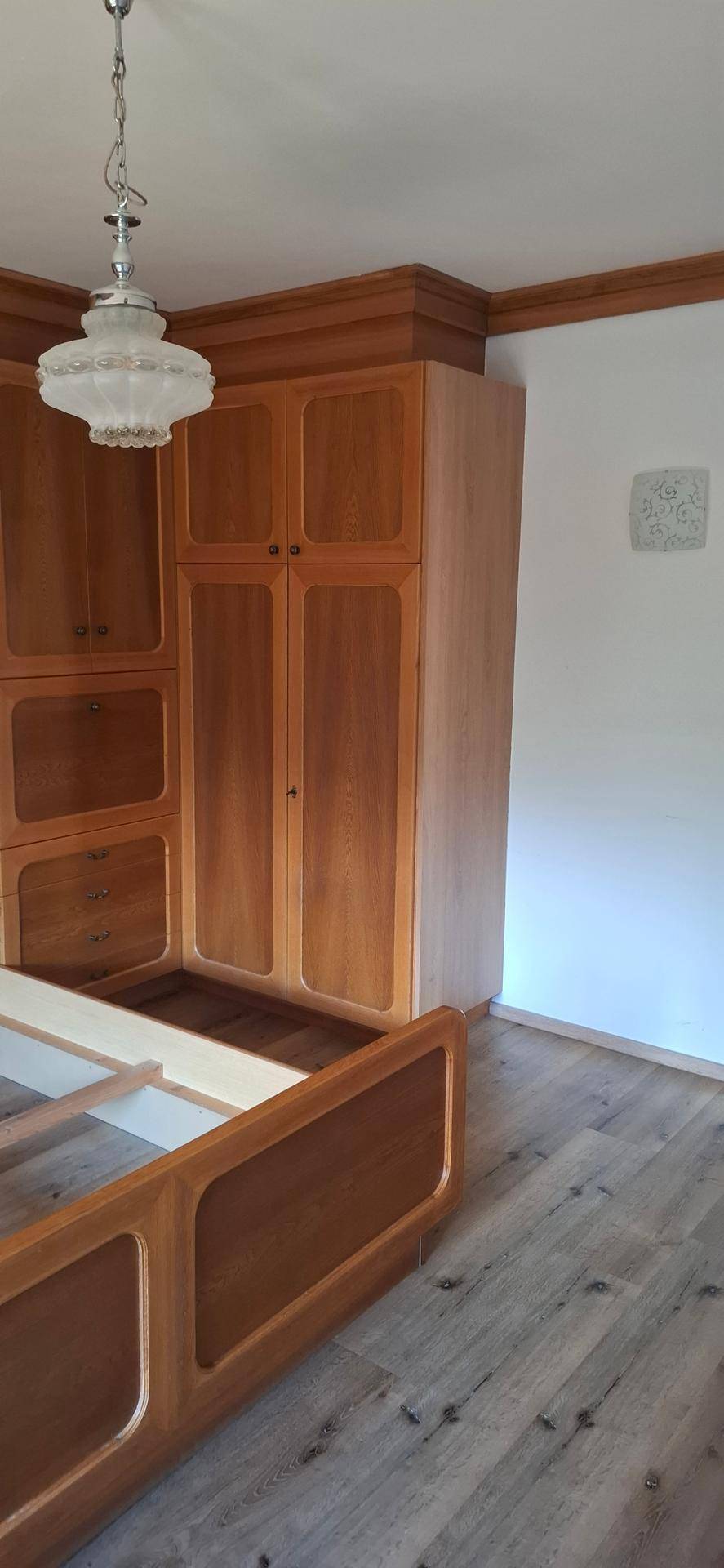 Schlafzimmer mit Holzbettrahmen und Einbauschränken, die eine gemütliche Atmosphäre schaffen.
