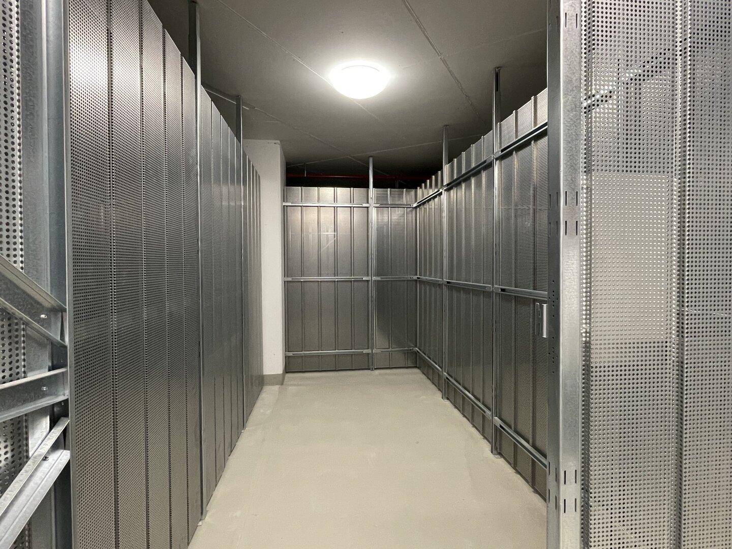 Geräumiger Abstellraum mit Metallwänden und Betonboden.