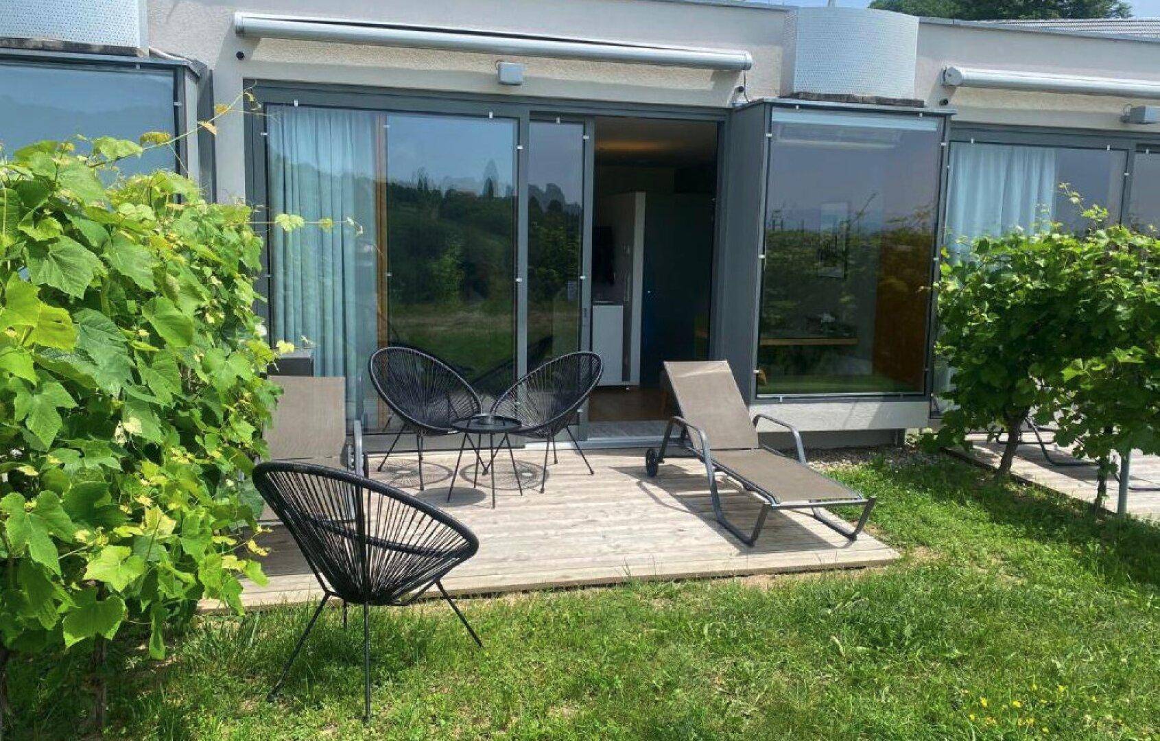 Gemütliche Terrasse mit modernen Gartenmöbeln und Blick auf die Weinberge.