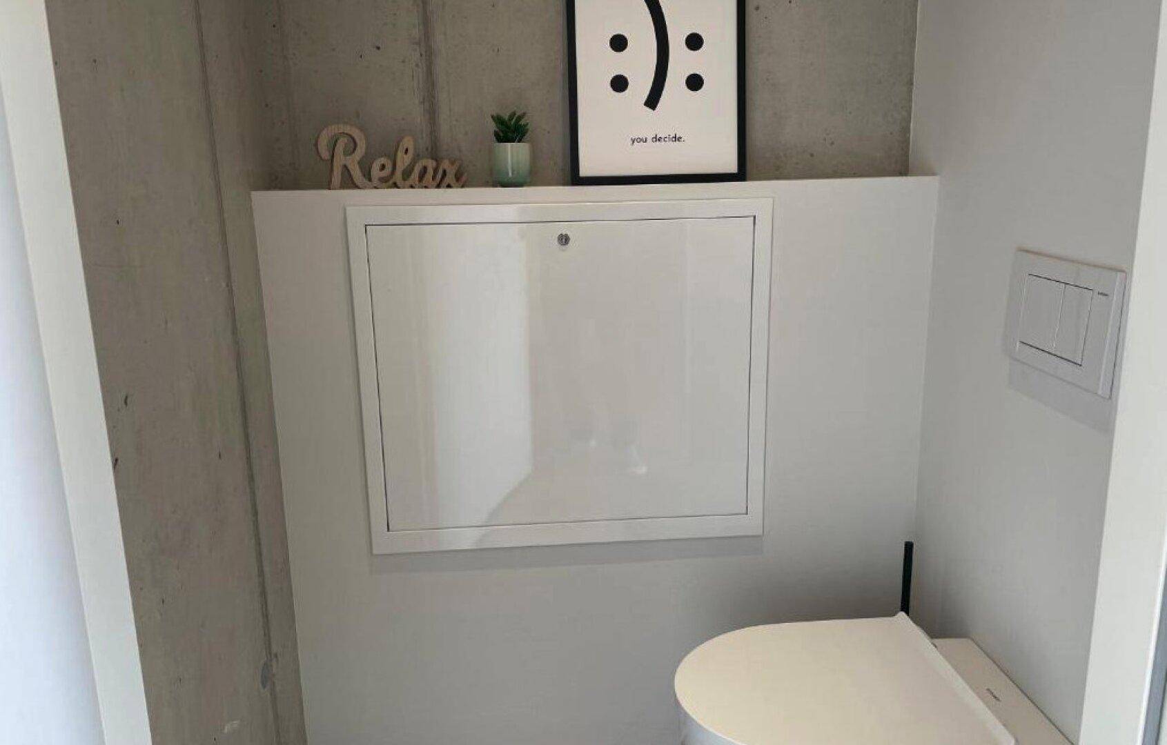 Modernes Gäste-WC mit wandmontierter Toilette und minimalistischer Dekoration.