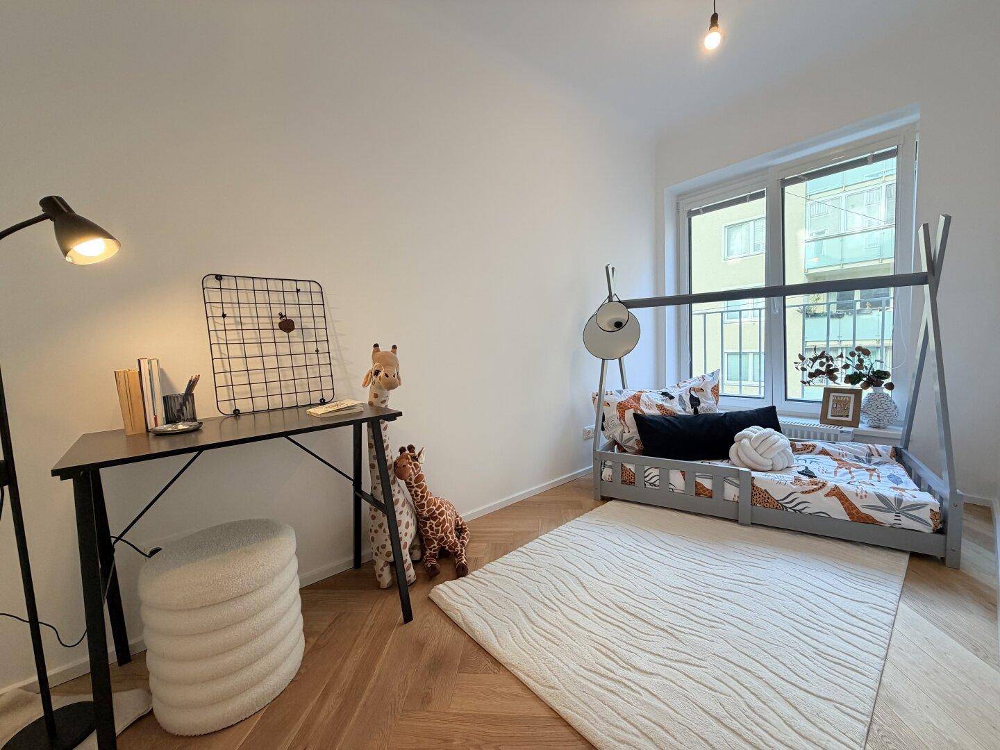 Kinderzimmer mit Holzbett, Schreibtisch und Fischgrätparkett, hell und freundlich gestaltet.