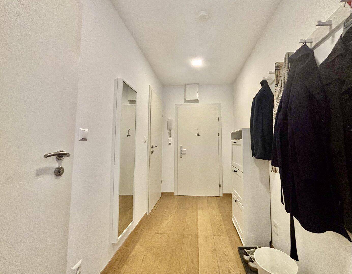 Eingangsbereich mit Garderobe, Schuhschrank und mehreren Türen.