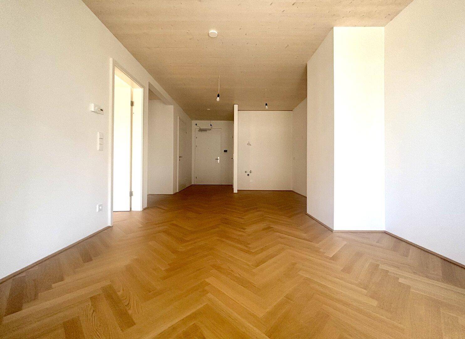 Geräumiger, leerer Raum mit Fischgrätparkett und hohen Decken, bereit zur individuellen Gestaltung.
