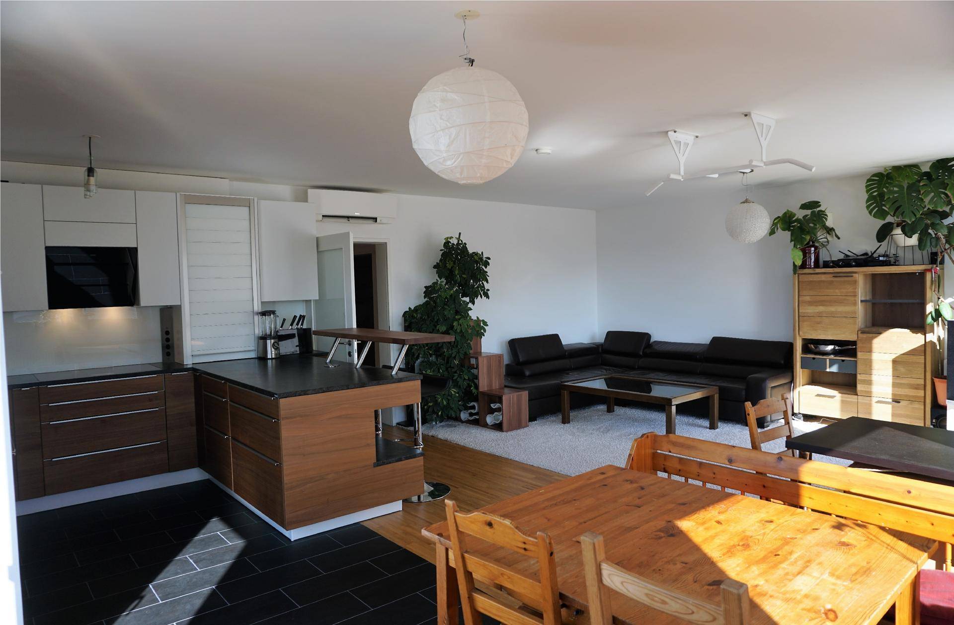 Geräumiger offener Wohn-Essbereich mit integrierter Küche und Holzboden.