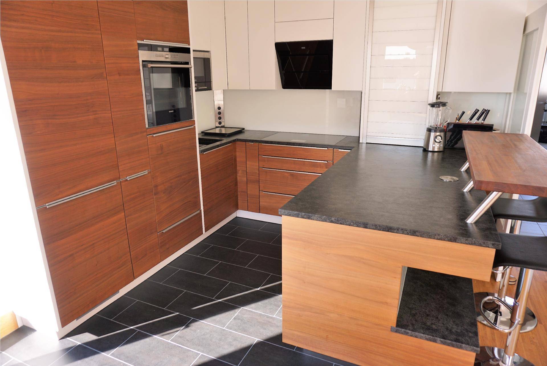 Detailansicht einer modernen Einbauküche mit integrierten Geräten und Kochinsel.