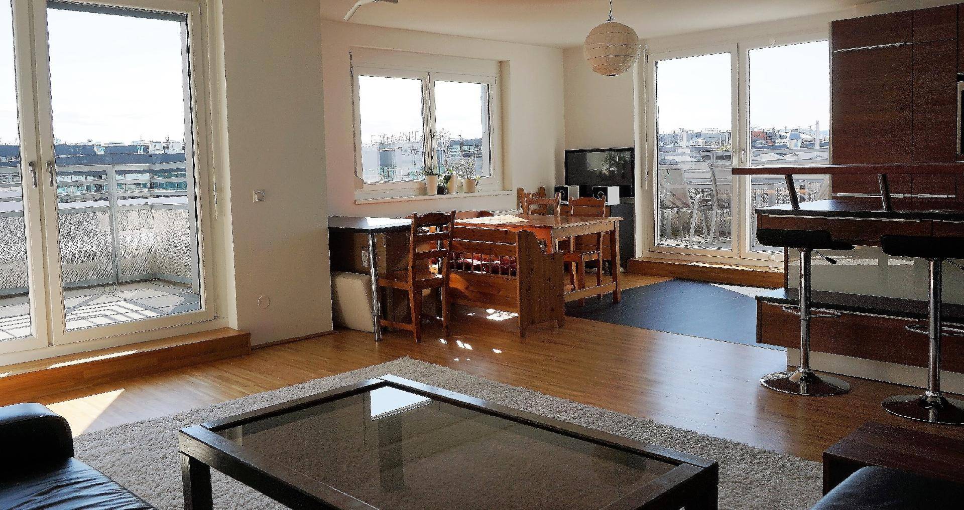 Heller Wohn-Essbereich mit großen Fenstern und Panoramablick über die Stadt.