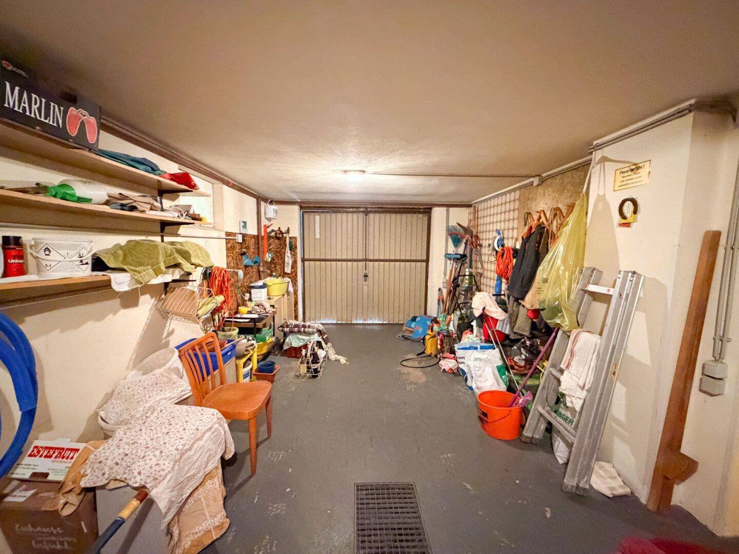 Geräumige Garage oder Abstellraum, gefüllt mit verschiedenen Gegenständen und Werkzeugen.