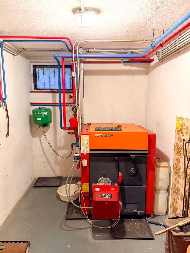 Hauswirtschaftsraum mit einer Heizungsanlage und sichtbaren Rohrleitungen, funktional eingerichtet.