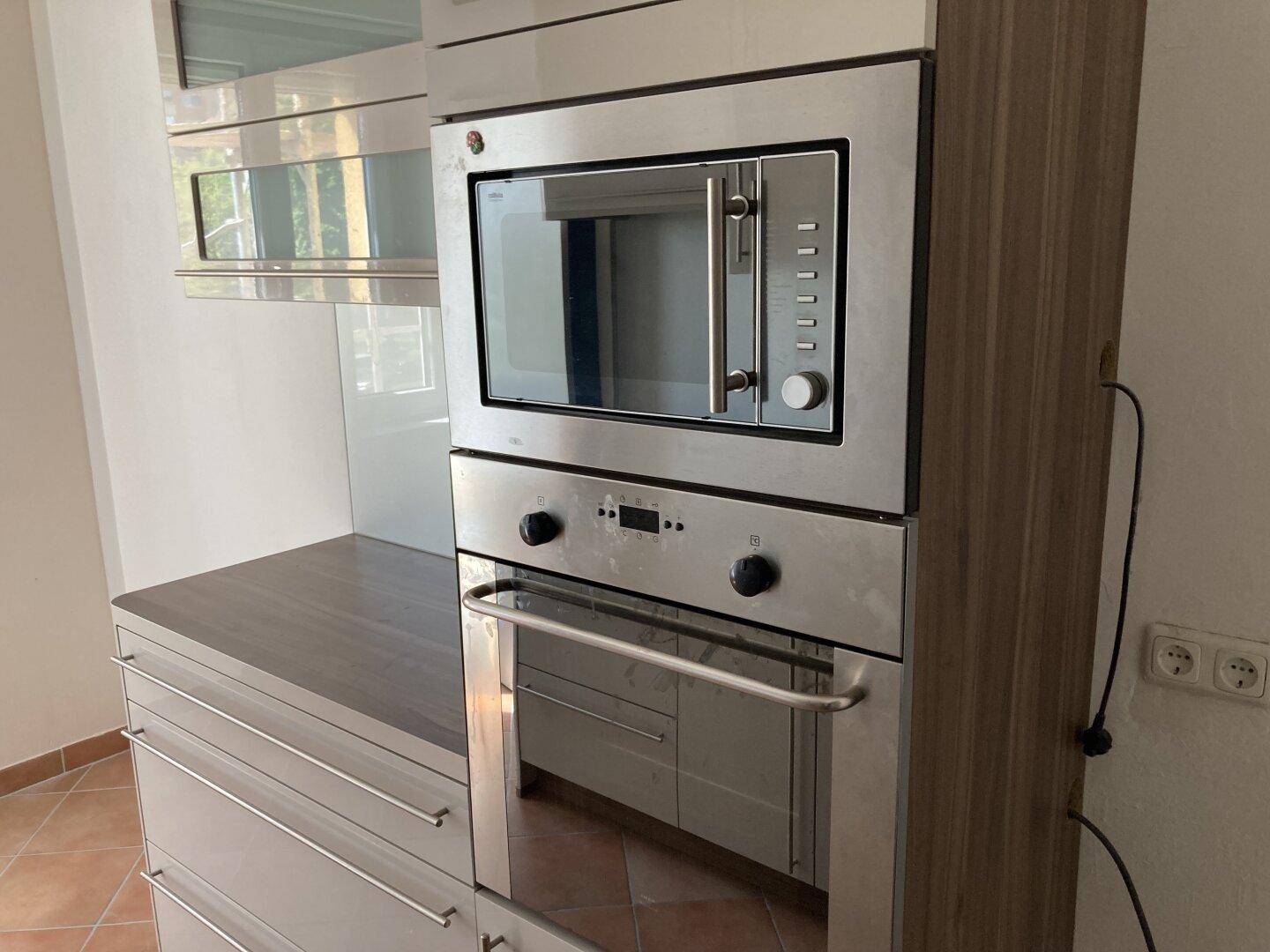Eingebauter Backofen und Mikrowelle in der modernen Küche mit Holzdekor.