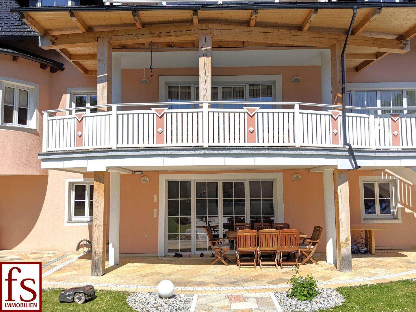 Gemütliche, überdachte Terrasse im Erdgeschoss mit Holztischgruppe und Zugang zum Garten.
