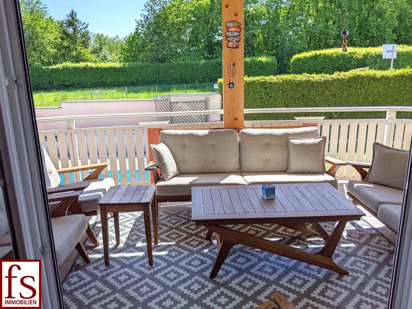 Gemütlicher Balkon mit modernen Outdoor-Möbeln und Blick ins Grüne, ideal zum Entspannen.