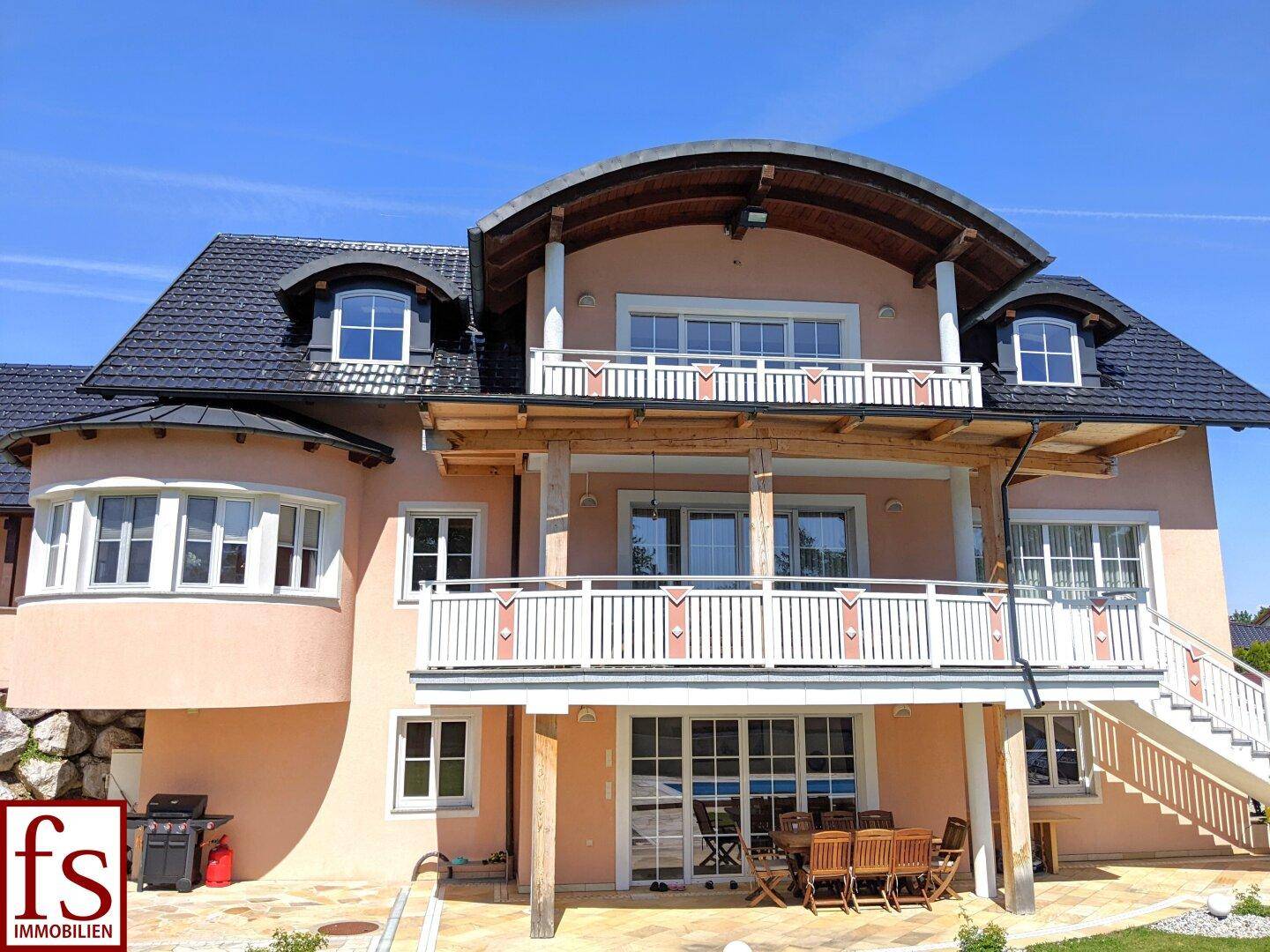 Attraktives Einfamilienhaus mit mehreren Balkonen, großem Garten und privatem Poolbereich.