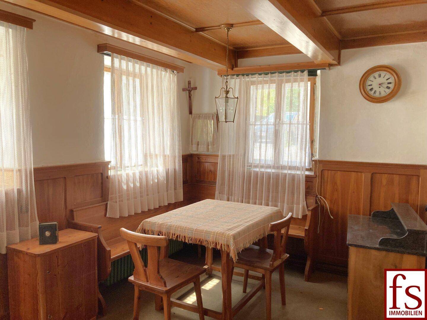 Gemütlicher Essbereich im traditionellen Stil mit Holztäfelung, Holzbalken und einem Esstisch.