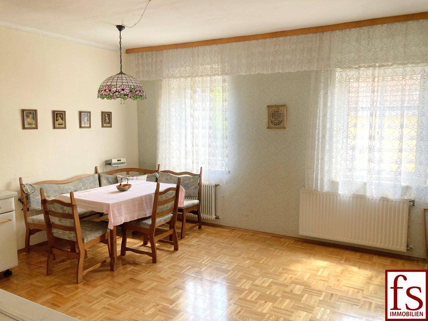 Heller Essbereich mit Parkettboden, Esstisch und einer traditionellen Deckenlampe.