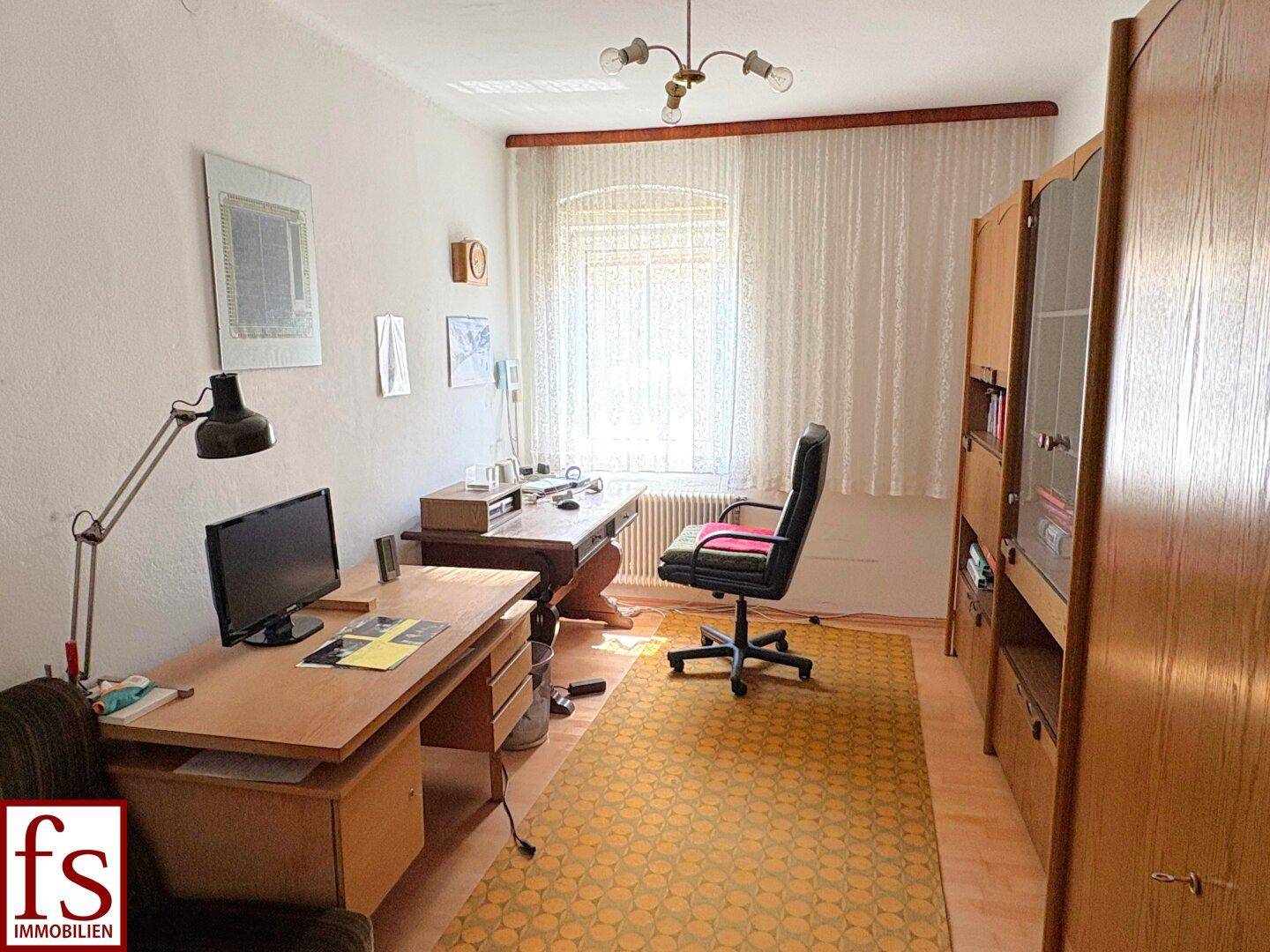 Helles Arbeitszimmer mit zwei Schreibtischen, Bürostuhl und Fenster, ideal für Home-Office.