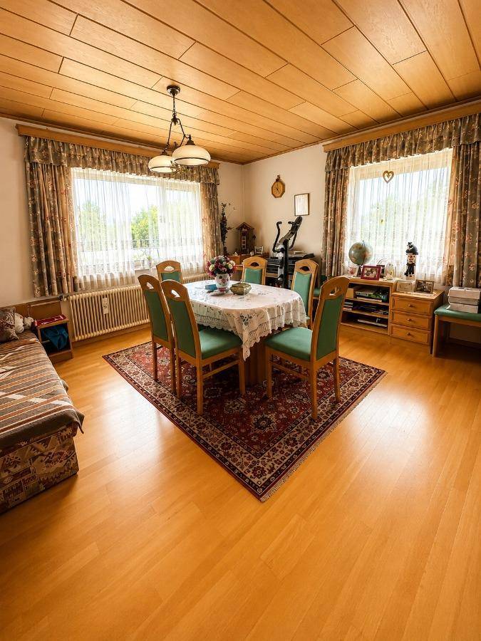 Geräumiges Esszimmer mit Holzbalkendecke, Laminatboden und traditionellen Möbeln für gesellige Runden.