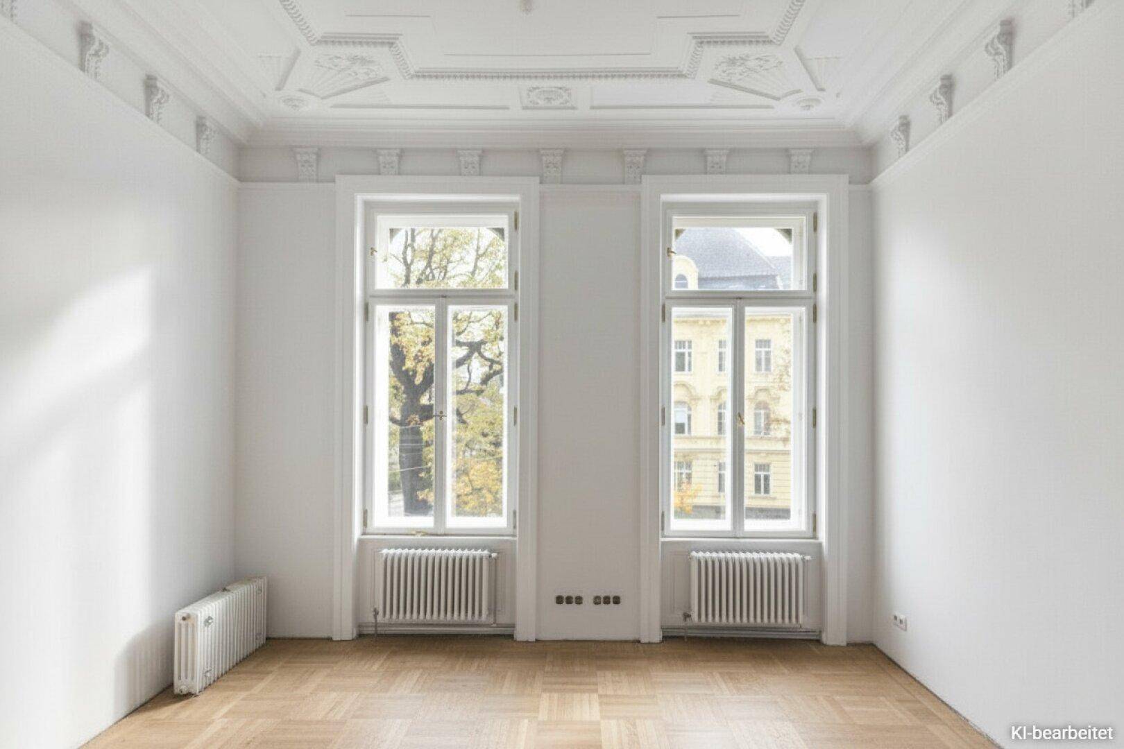 Helles Zimmer mit Stuckdecke, hohen Fenstern und klassischem Fischgrätparkett.