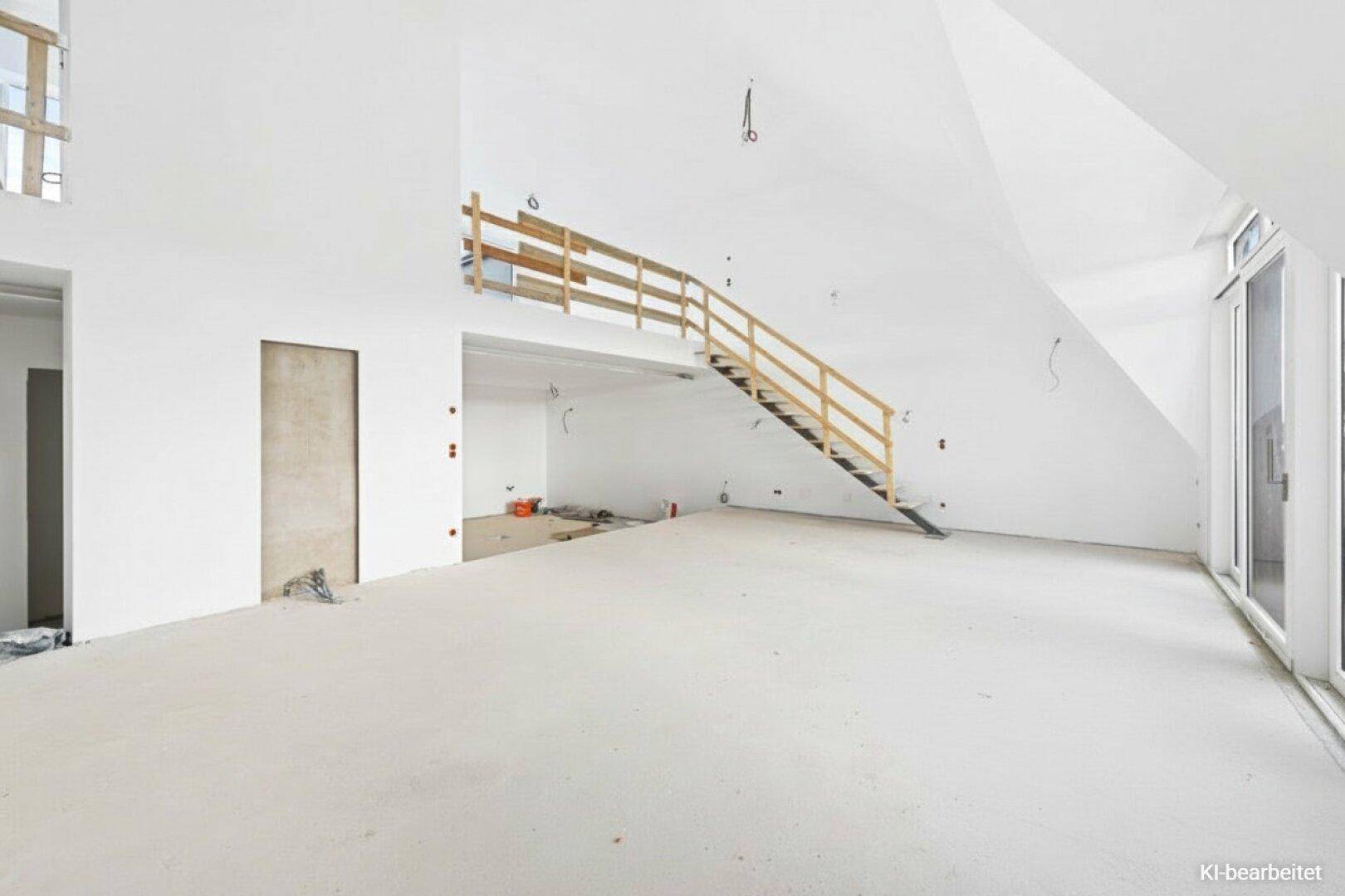 Rohbau-Innenraum mit großen Fenstern, Betonboden und einer Holztreppe im Bauzustand.