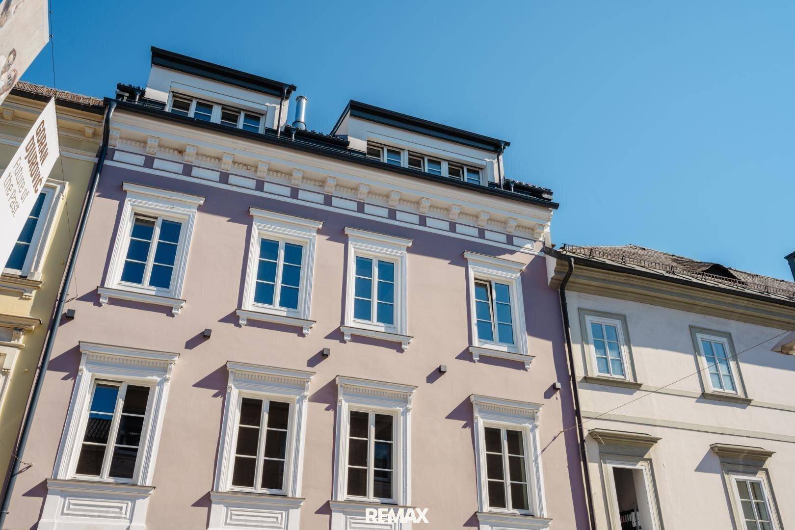 Historische Fassade eines Gebäudes mit eleganten Fenstern und klassischer Architektur.