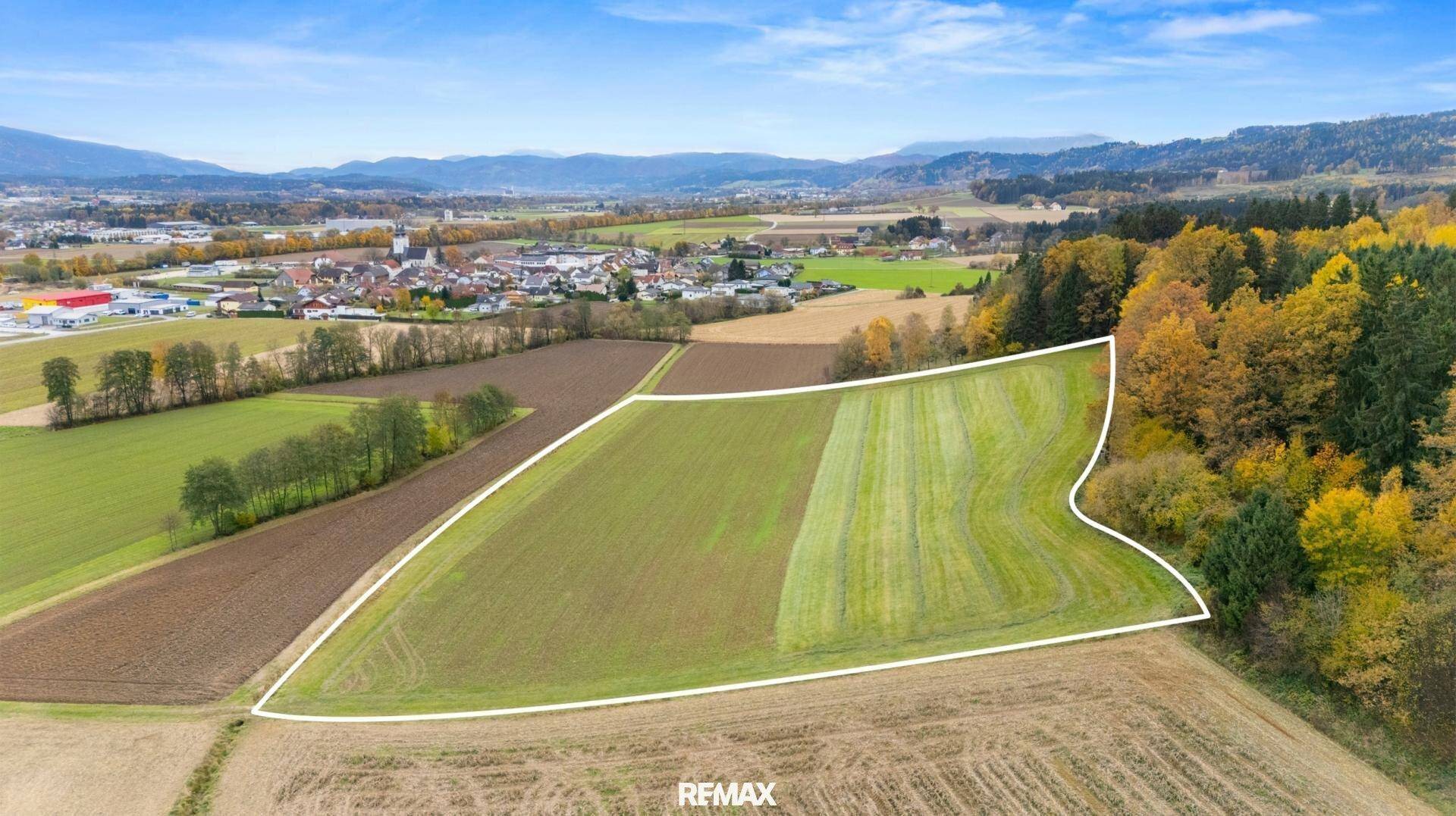 Luftaufnahme einer großen landwirtschaftlichen Fläche mit markierten Grenzen und umliegender Natur.