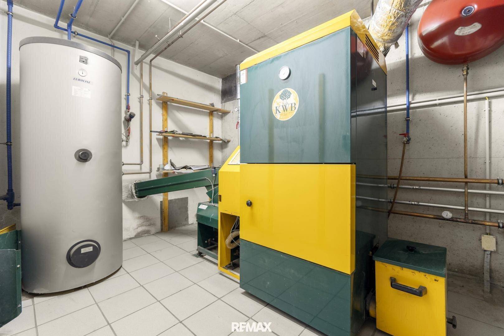 Heizraum mit großem Boiler und Heizungsanlage, ausgestattet mit Fliesenboden.