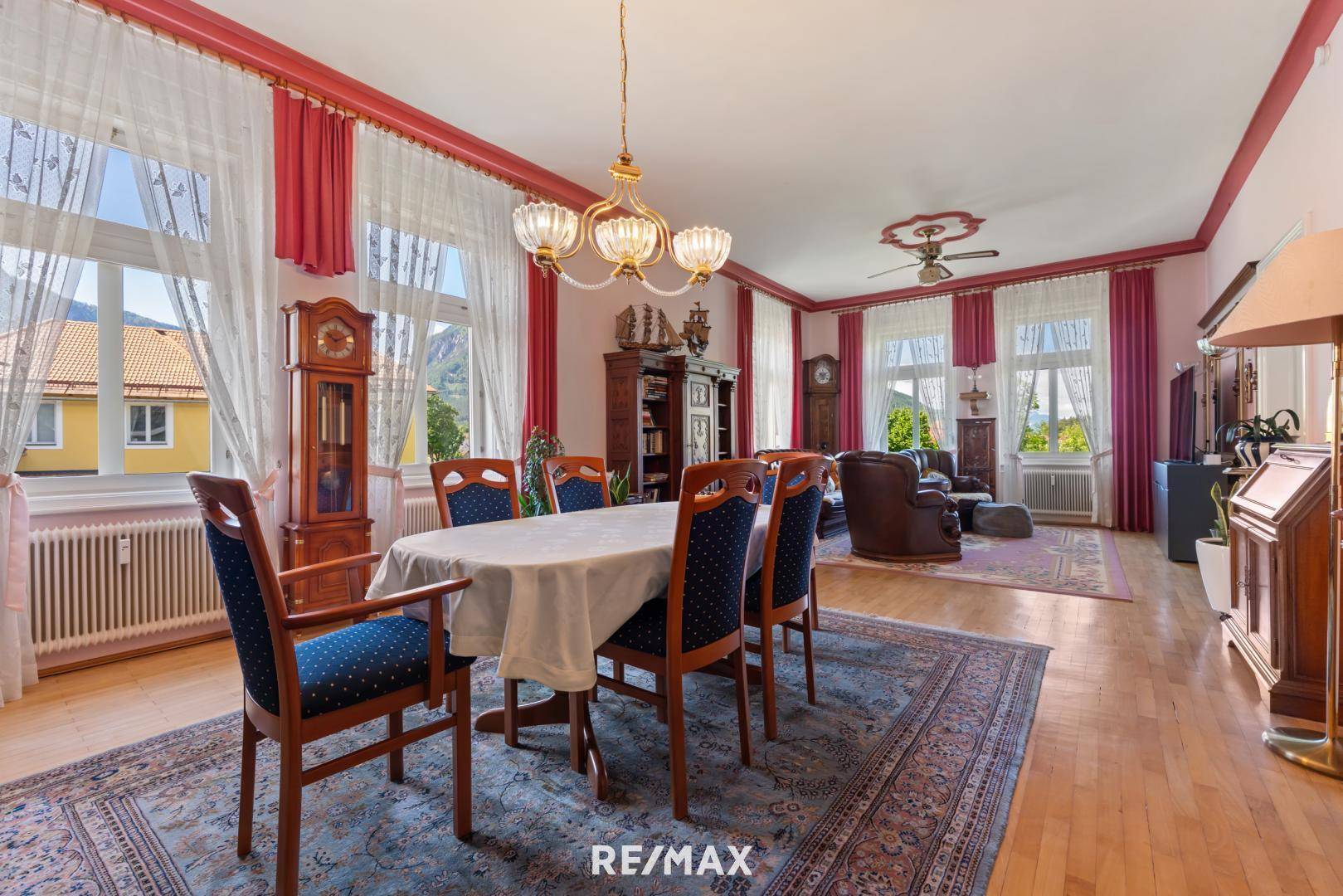 Geräumiger Wohn-Essbereich mit traditionellen Möbeln, Parkettboden und Blick auf die Berge.