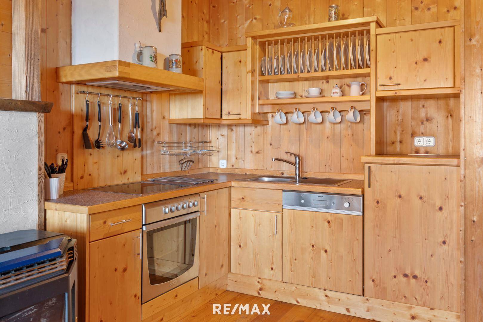 Rustikale Holzküche mit integrierten Geräten, traditionellen Schränken und viel Stauraum.