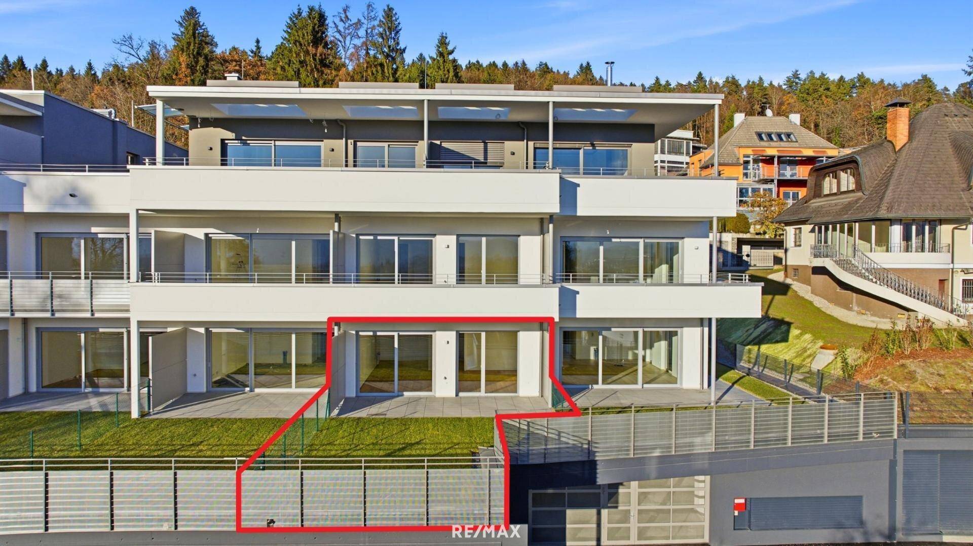 Ansicht der modernen Wohnanlage von außen, mit hervorgehobener Erdgeschosswohnung und Garten.