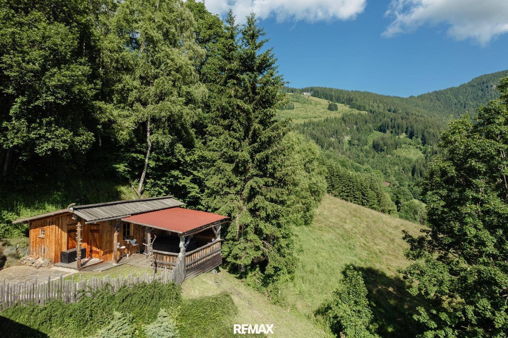 Panoramablick auf ein Anwesen in den Bergen, umgeben von üppiger Natur und Wäldern.