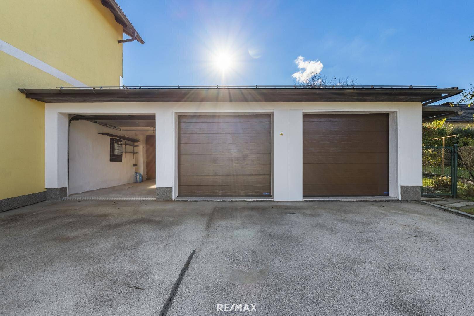 Geräumige Dreifachgarage mit braunen Toren und viel Sonnenlicht.