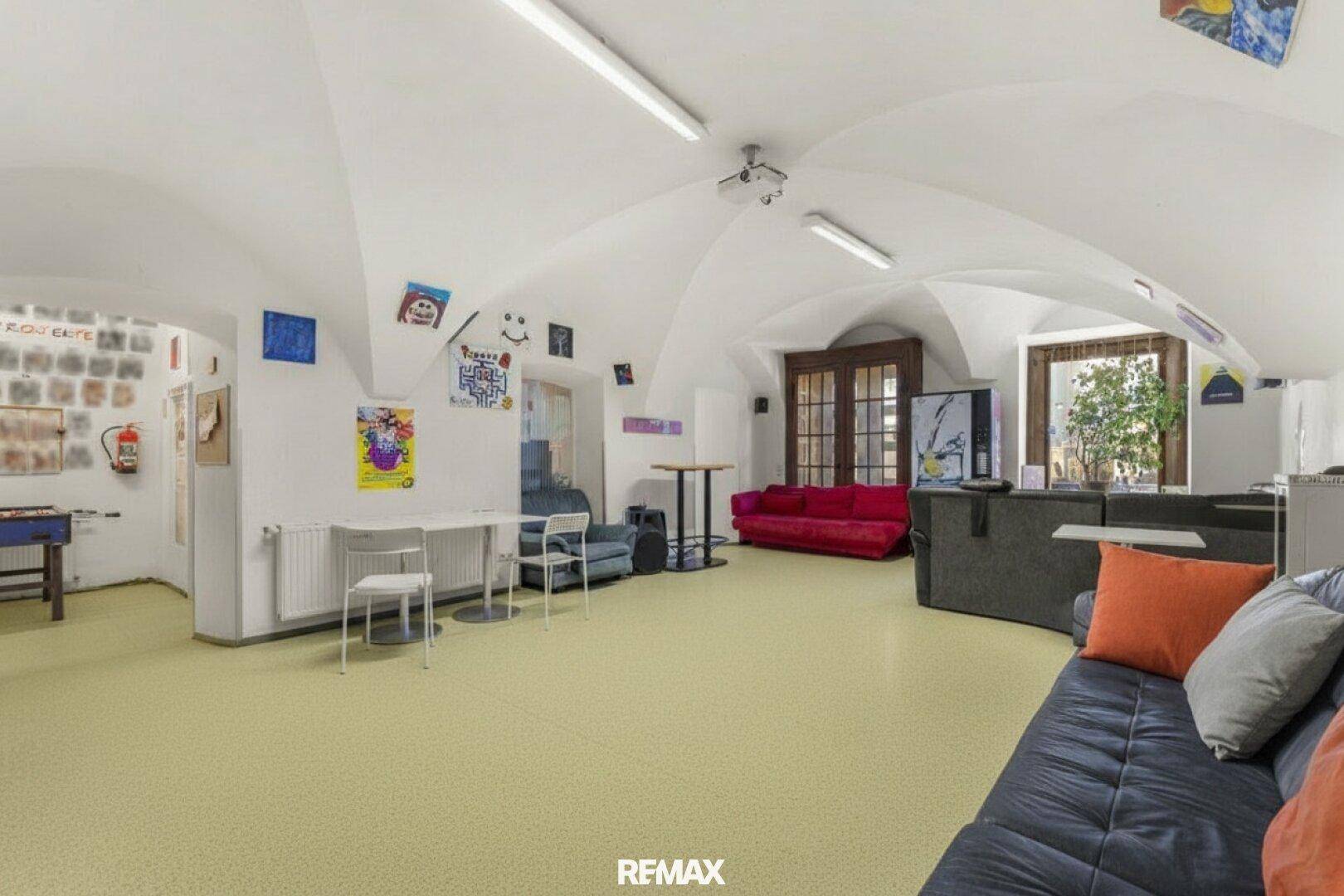 Großer Mehrzweckraum mit gewölbter Decke und hellem Boden, ausgestattet für Freizeitaktivitäten.