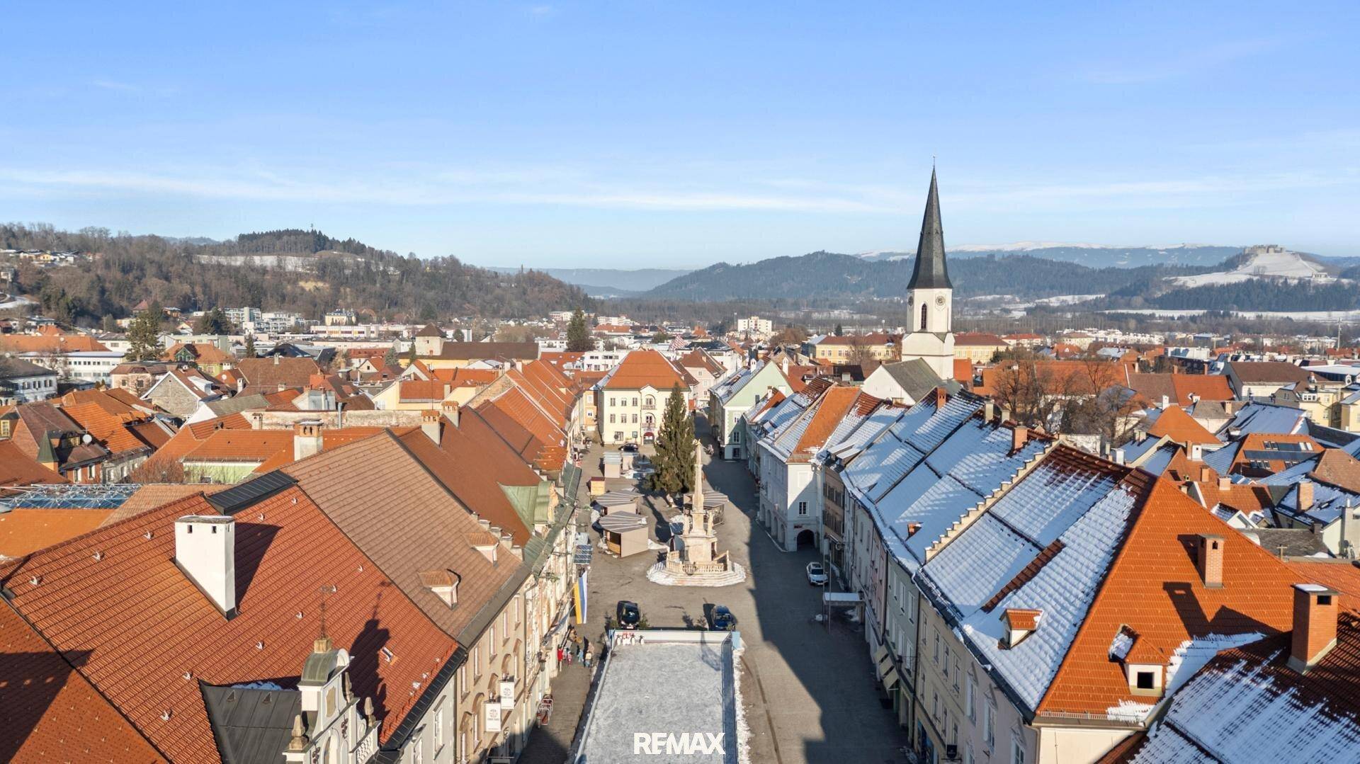 Panoramablick über die historische Stadt mit Kirche und schneebedeckten Dächern.