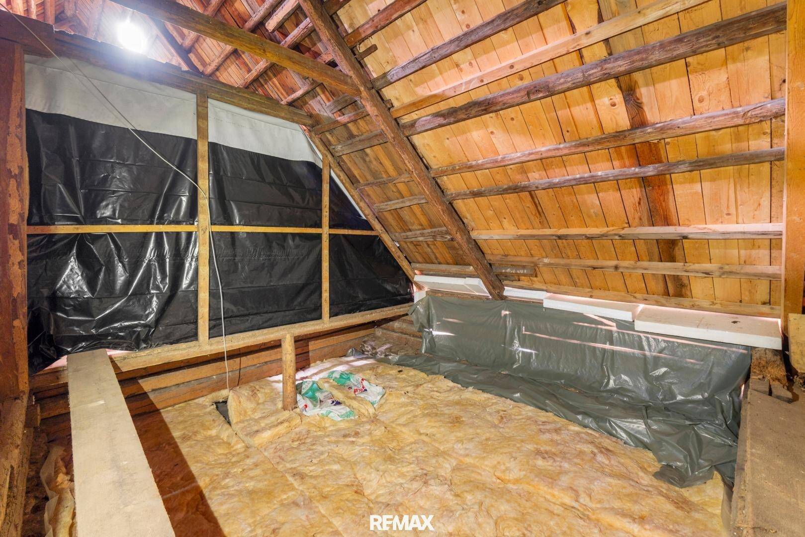 Dachboden mit sichtbarer Holzkonstruktion und Isolierung, bereit für den weiteren Ausbau.