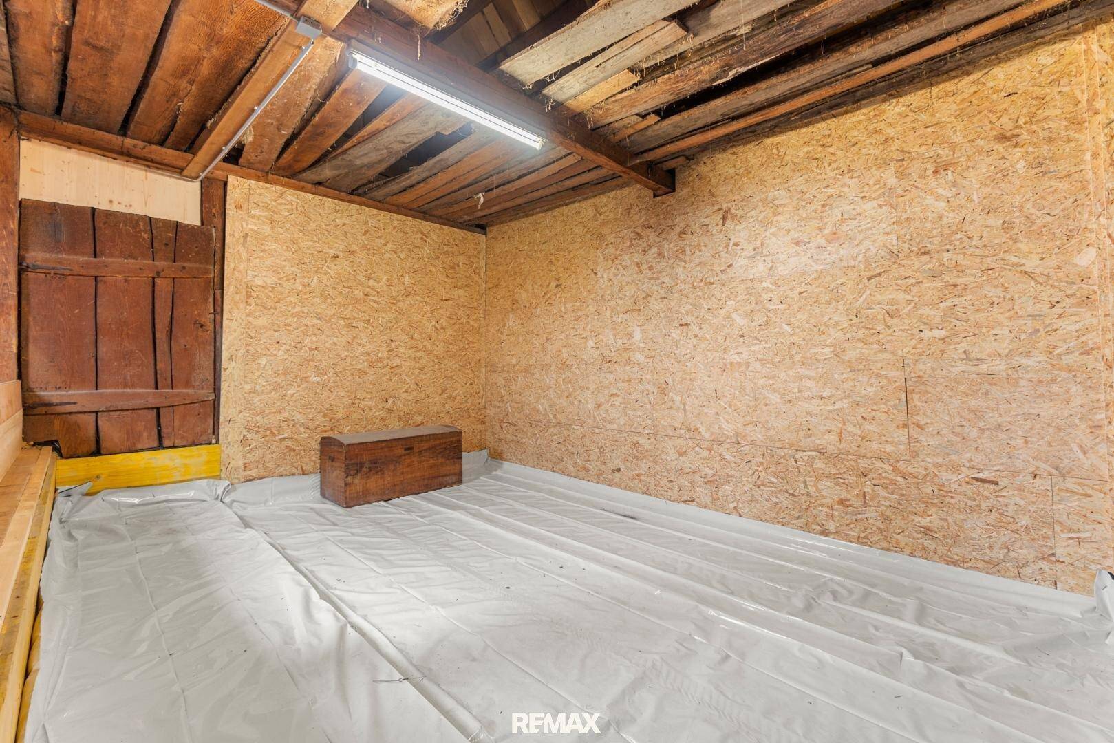 Ausbaufähiger Dachbodenbereich mit Holzbalken und OSB-Platten, ideal für zusätzlichen Wohnraum.