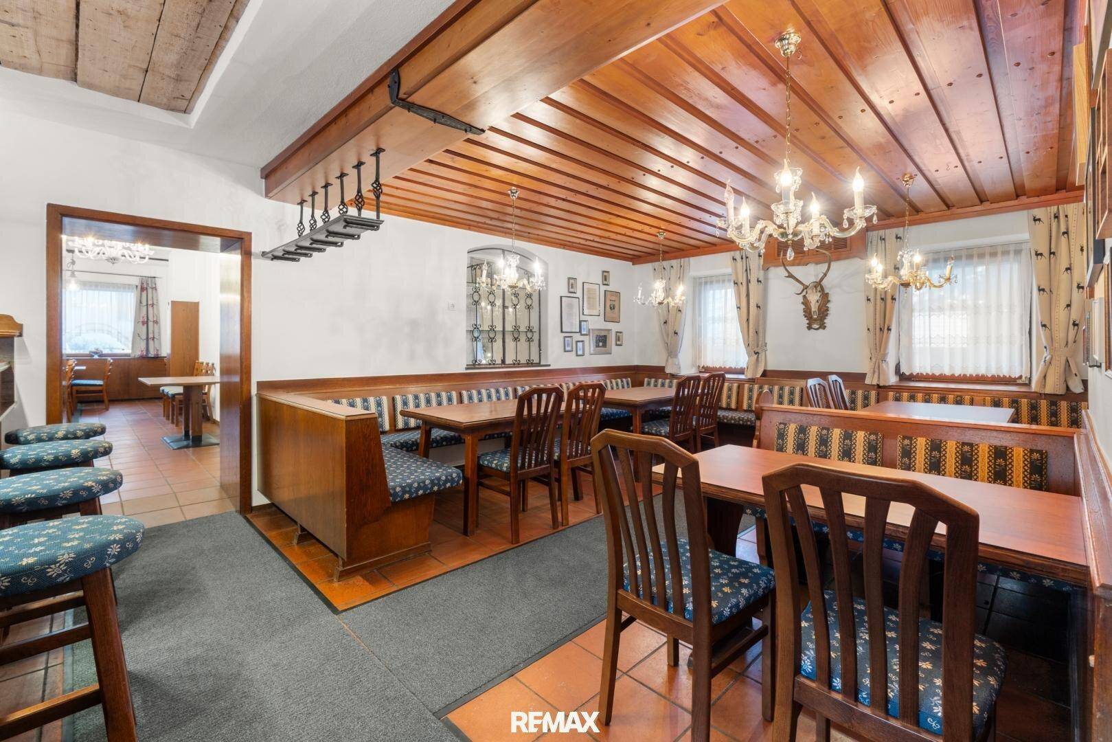 Gemütlicher Restaurantbereich mit Holzbalkendecke, traditionellen Sitzbänken und Terrakottafliesen.