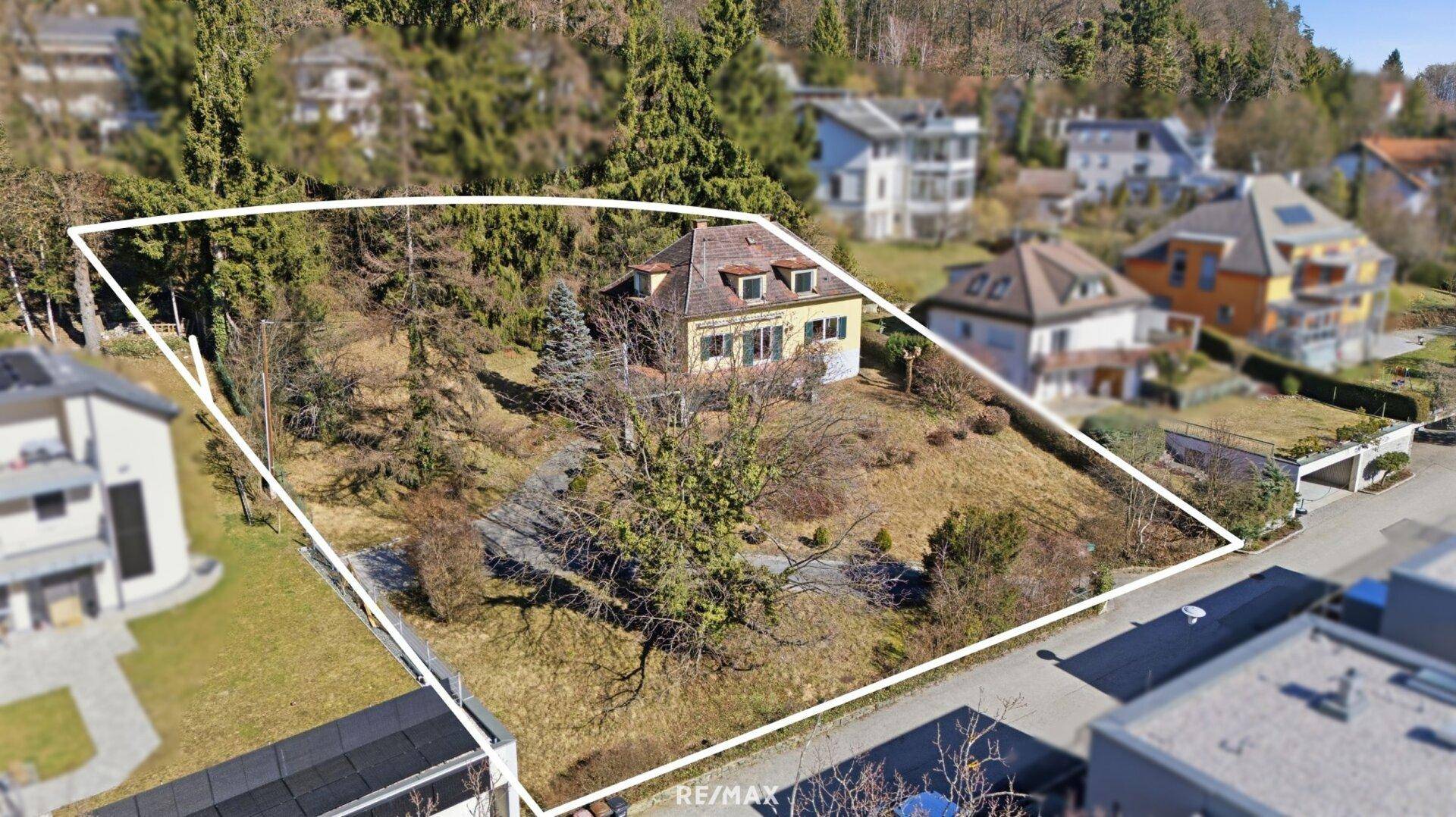 Übersicht des Grundstücks mit freistehendem Haus und großzügiger Grünfläche in Hanglage.