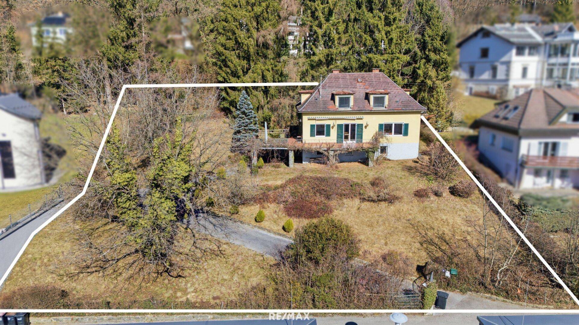 Vorderansicht des Einfamilienhauses mit Garten in Hanglage und Zugang zur Terrasse.