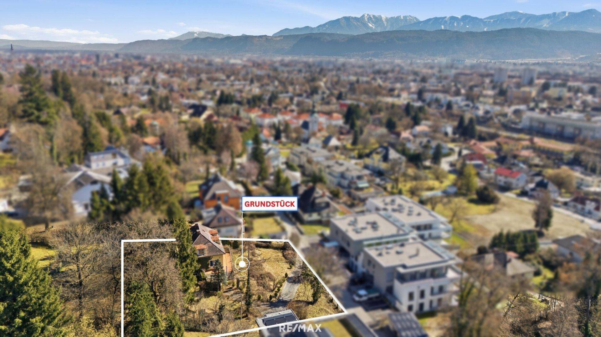 Luftaufnahme des gesamten Grundstücks mit Haus und Panoramablick auf die Bergwelt.