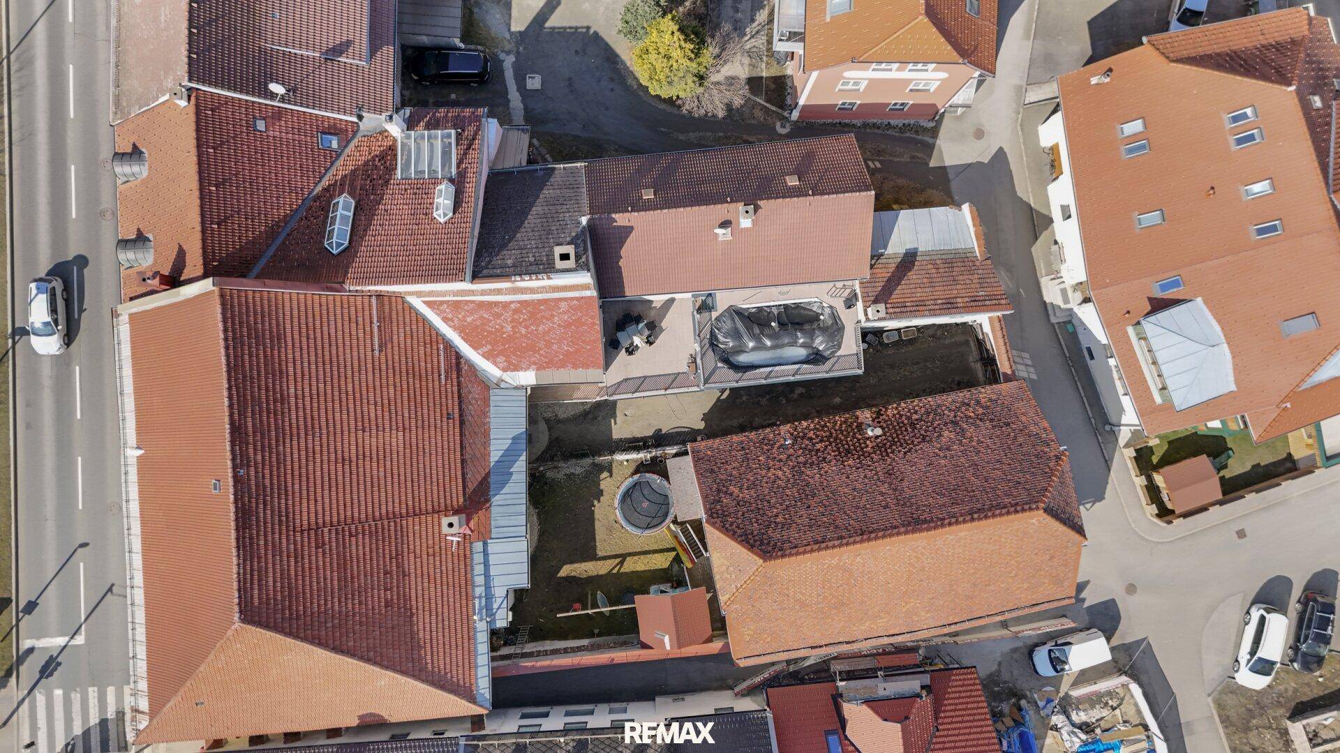 Luftaufnahme des Hinterhofs mit Pool, Gartenbereich und umliegenden Dächern.