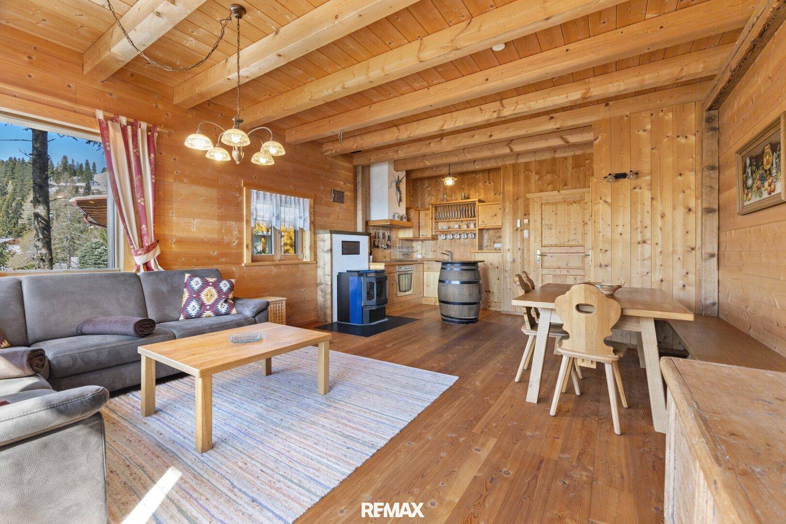 Geräumiger Wohn- und Essbereich im Chalet-Stil mit Holzbalken und rustikalen Möbeln.