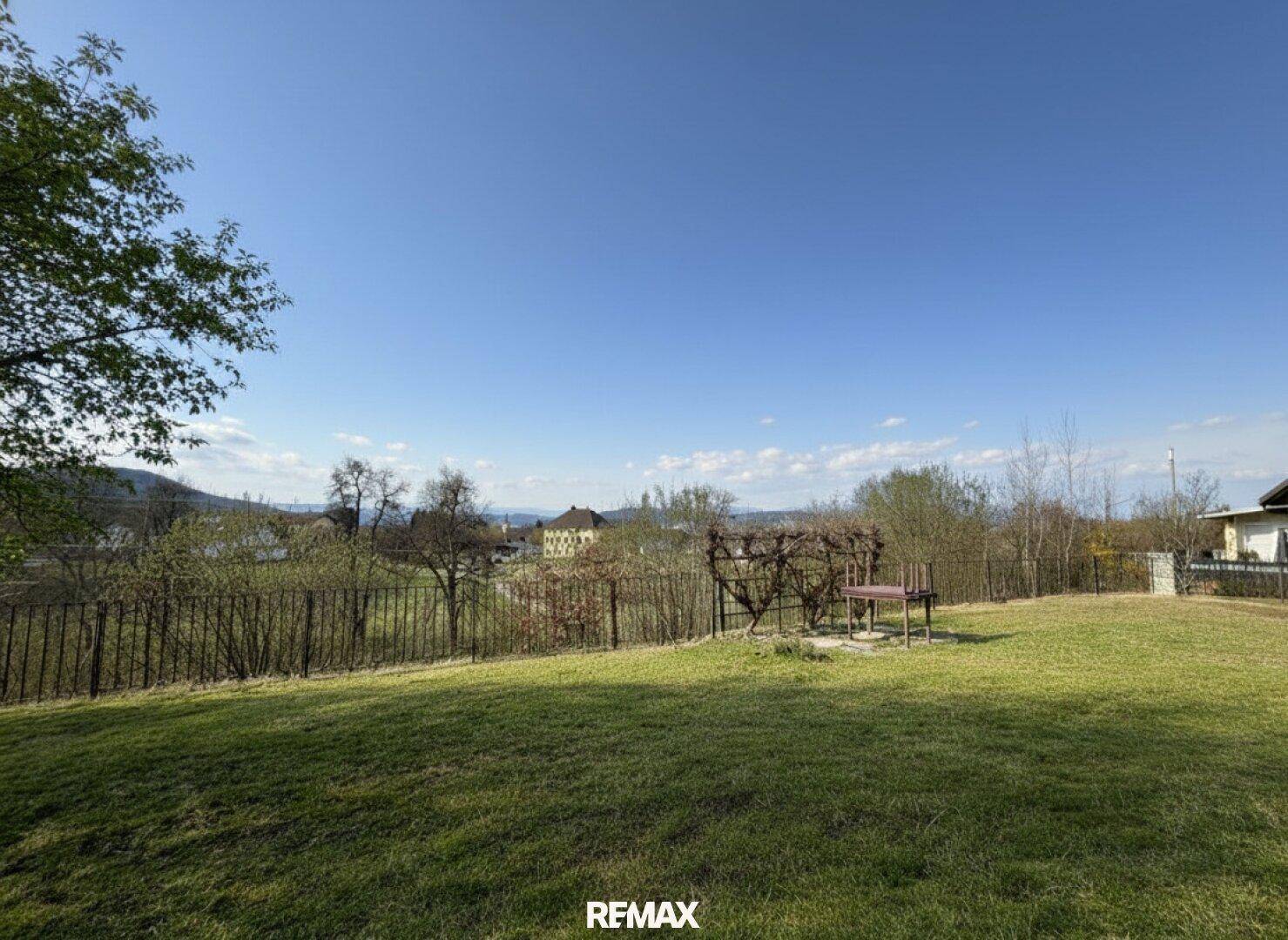 Weitläufiger Gartenbereich mit Rasenfläche und Panoramablick über die umliegende Landschaft.