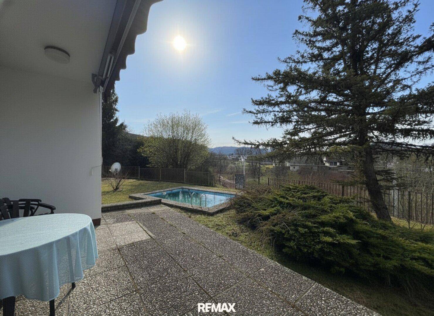 Sonniger Terrassenbereich mit kleinem Pool und weitem Blick über die Landschaft.